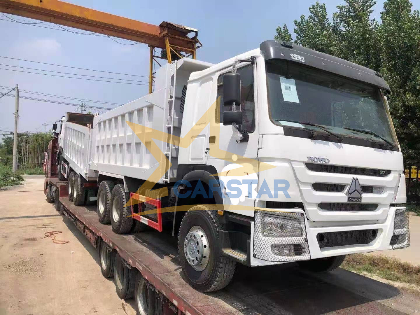 Trois camions à benne d'occasion commandés par un client nigérian sont en cours de chargement